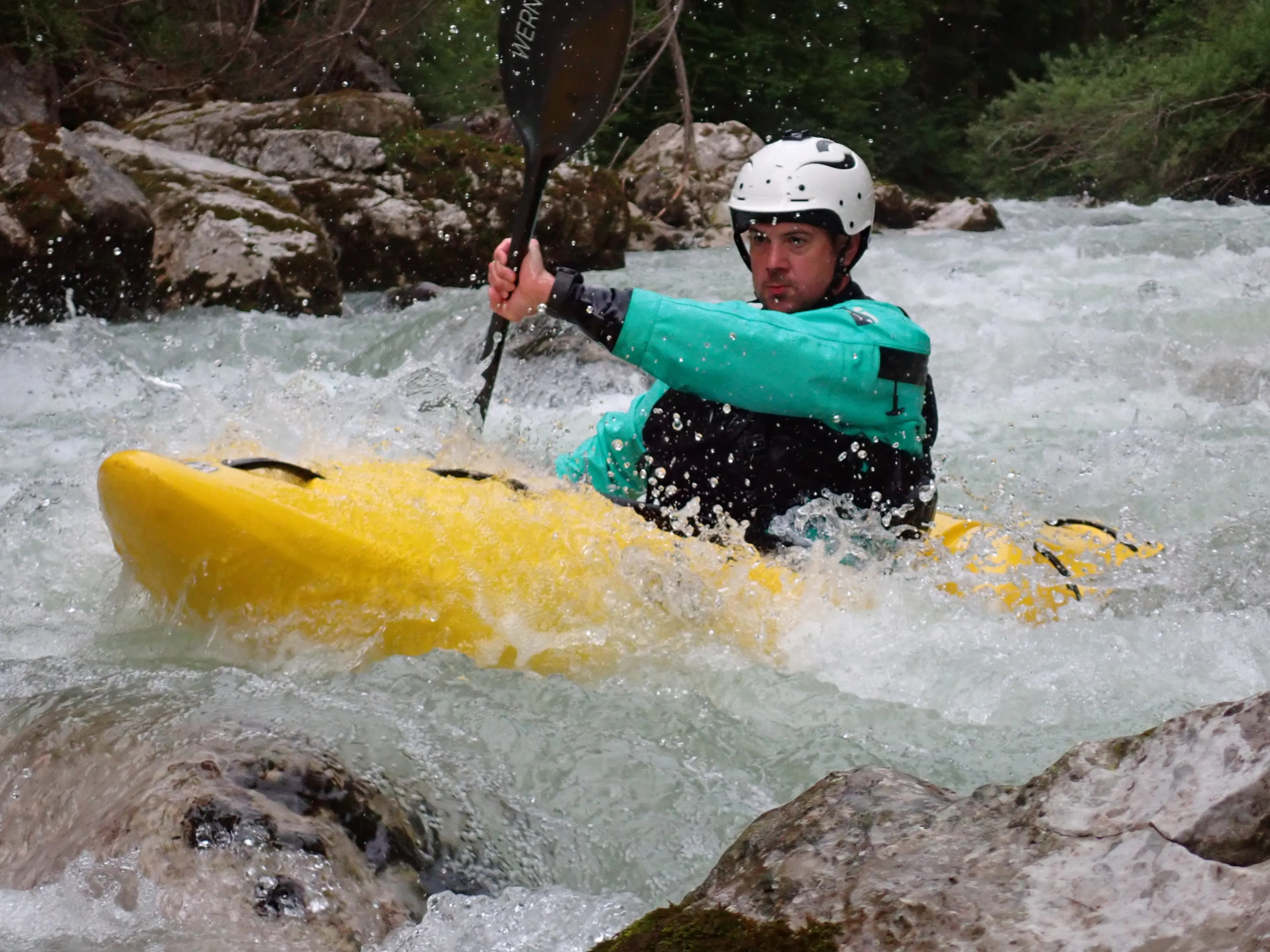 Coach briefing a kayaker before a whitewater coaching session