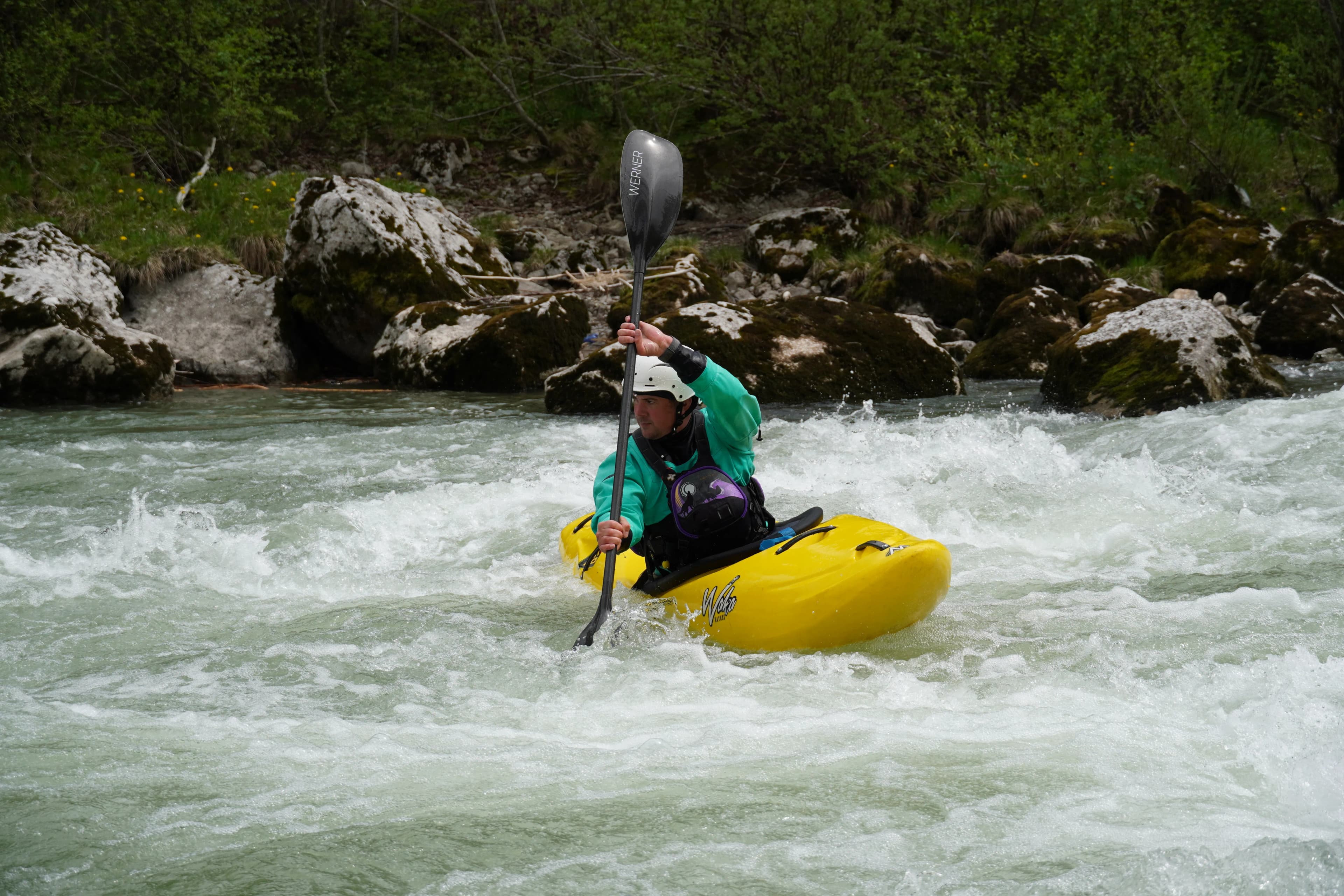 Kayaker fully focused while navigating a whitewater rapid